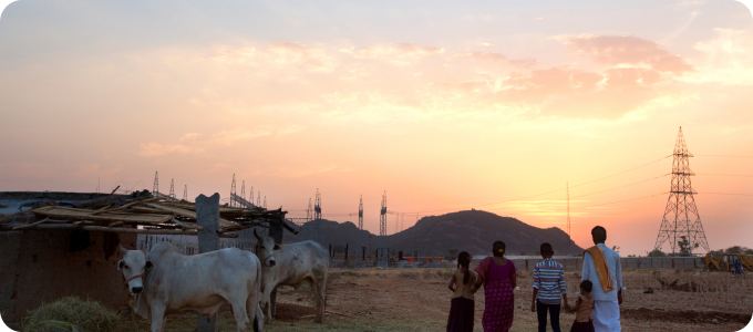 Village at sunset near a transmission tower